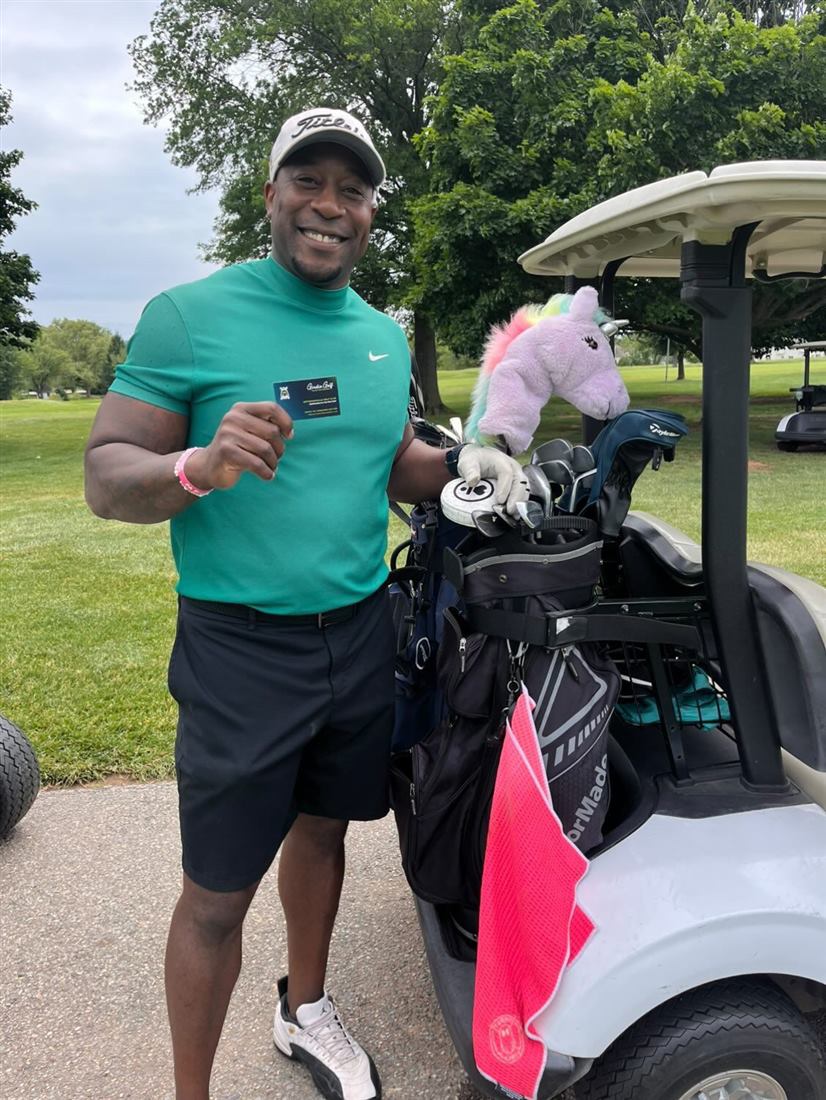 A golfer holding the gift card he won at the Girdie Golf challenge