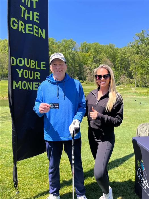 A Girdie Golf staffer handing a gift card to a winning golfer