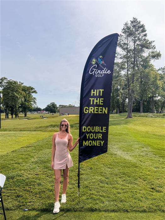 A Girdie Golf staffer with the banner on an empty fairway